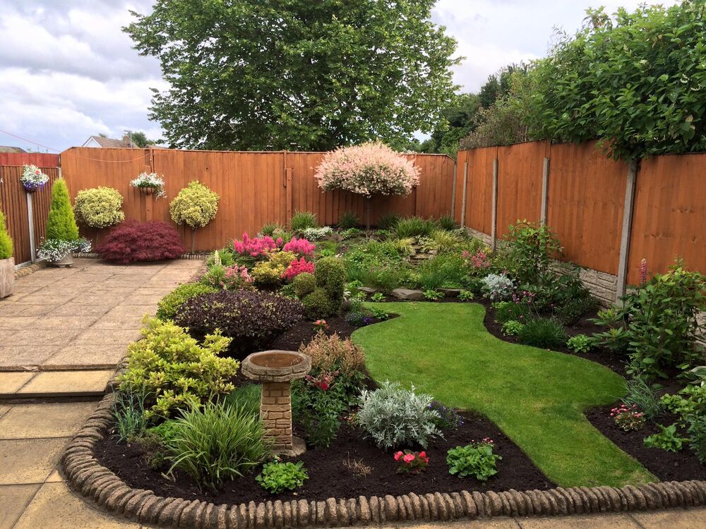 Shaped planted borders around a cut lawn in another Merseyside garden.