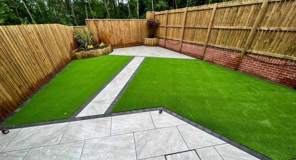A porcelain-paved patio with a laid lawn and raised planted beds.